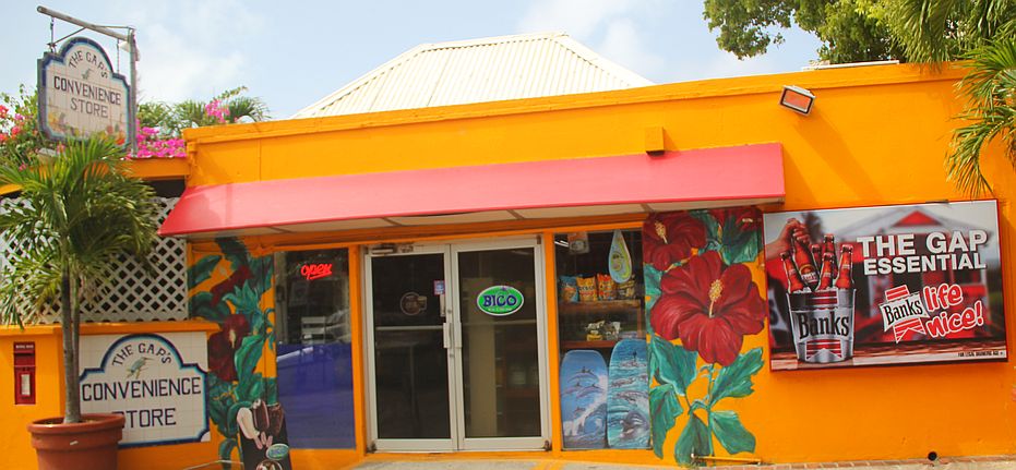 Exterior view of the colorful Gap's Convenience Store with floral mural and Banks Beer sign
