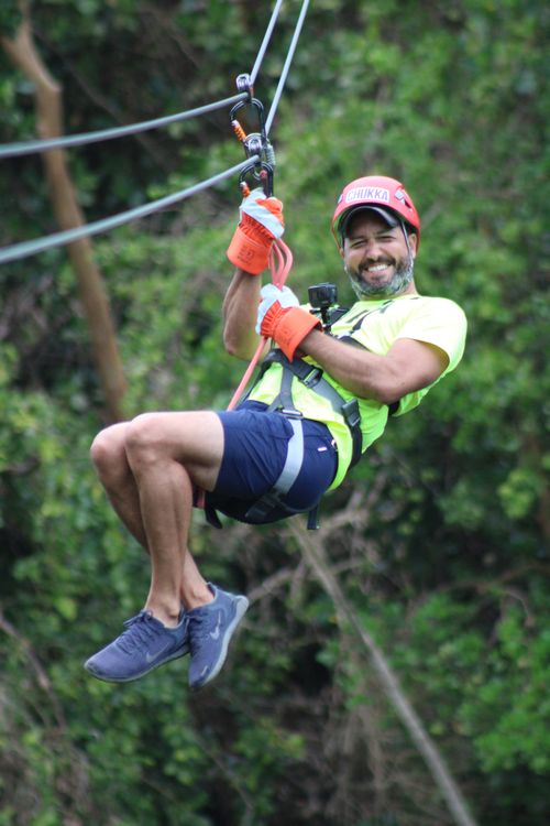 Man smiling as he ziplines at Harrison’s Cave Eco-Adventure Park